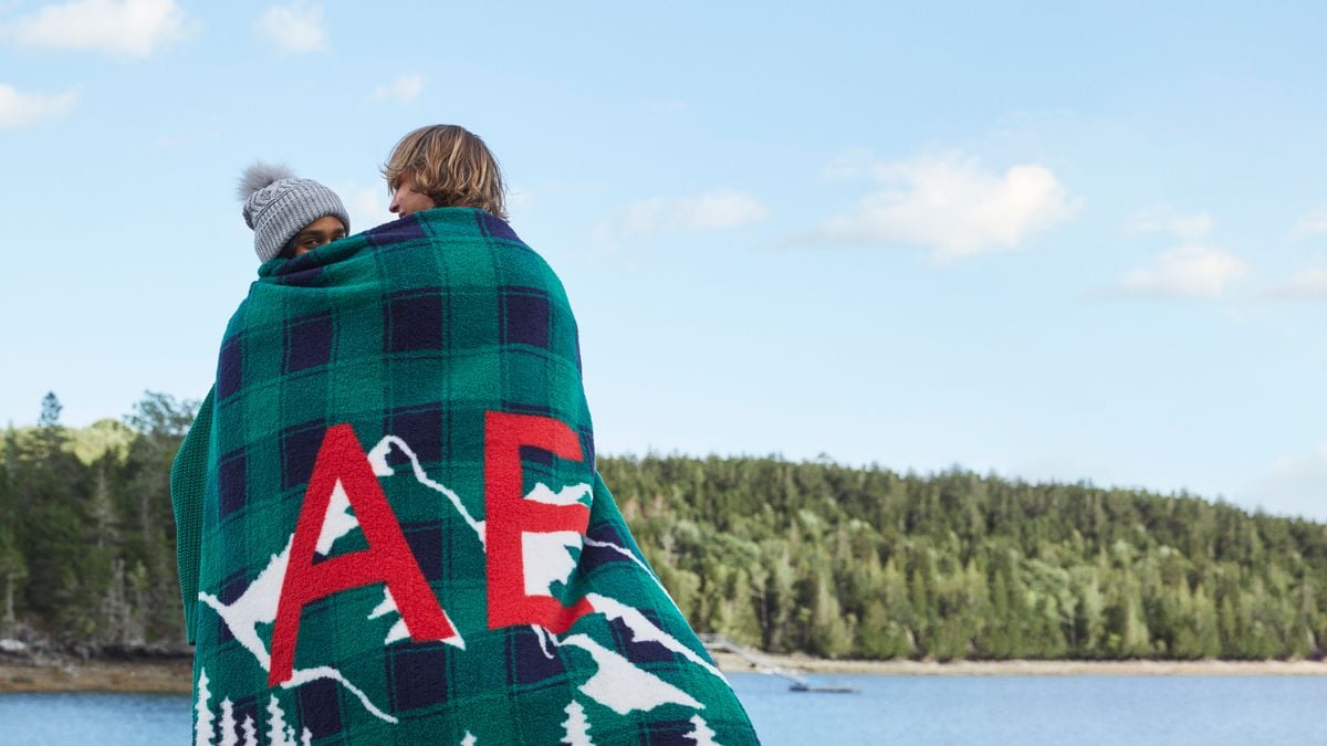 Two people standing wrapped in a blanket as part of American Eagle's 2022 holiday campaign.
