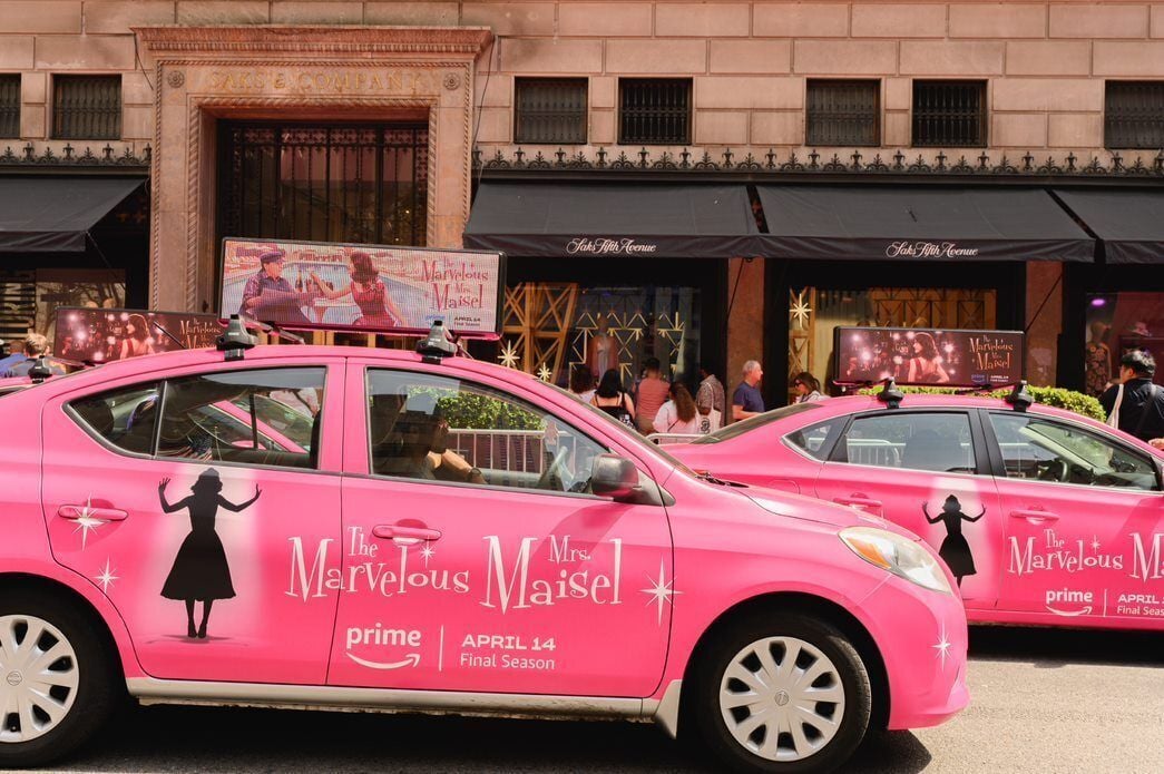 Two pink taxis branded sit outside Saks Fifth Avenue in New York as part of a branded effort by Amazon Prime Video promoting its "The Marvelous Mrs. Maisel" series.
