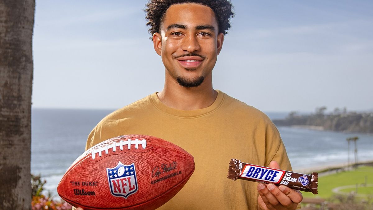 Bryce Young holds a football and limited-edition Snickers Ice Cream Bar.